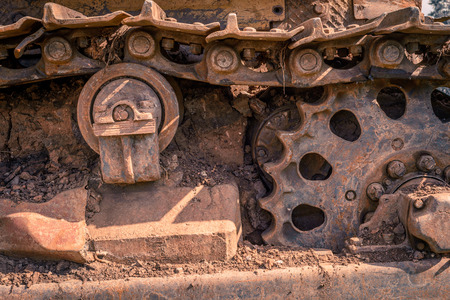 Rusty and dirt covered mechanical caterpillar track with aged cogs and wheels.の写真素材