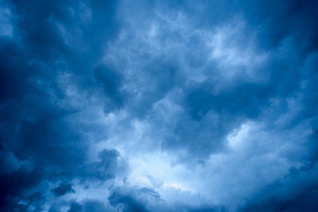 Overhead dark blue storm clouds and white areas and copy space for text overlaysの写真素材