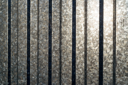 Aluminium sheeting in vertical with sunlight reflecting off the metal surfaceの写真素材