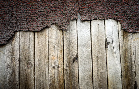 Cracked and peeling aged bitumen waterproofing coat on wood