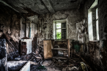 Old forgotten and abandoned home interior in a derelict decaying state with grimy floors and ripped wallpaper.の写真素材