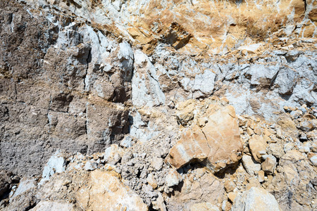 Layers of grey mud and earth exposed by beach erosion and the seaside elements