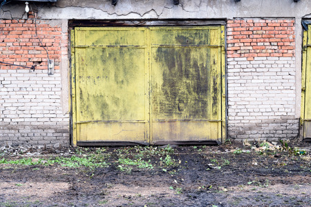 Old yellow painted metal door in a vintage grunge style composition.の写真素材