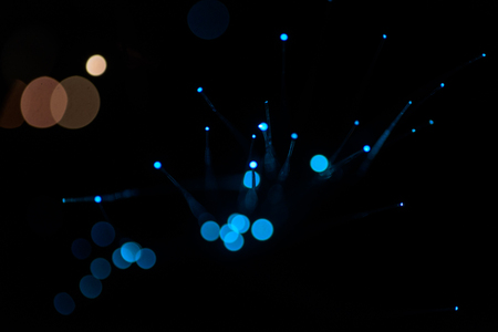 Abstract soft blue lights using a defocused bokeh effect with a black background. The sparkling colored lighting is created from the blur of intense Christmas decorations.の写真素材