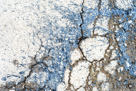 Black poured tar marks the pothole areas of a road so the holes in the old street can be repairedの写真素材