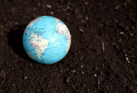 Color globe of planet earth with a dirt mud backgroundの写真素材
