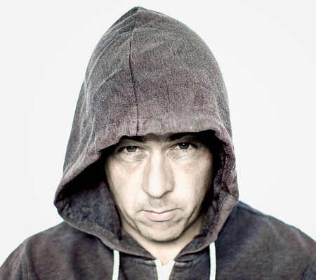 Man with a mean and moody face wearing a grey hooded top with intentional grain and a grunge lookの写真素材
