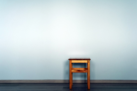 Wood pine stool set against a blank blue wall background with copyspace area for text overlaysの写真素材