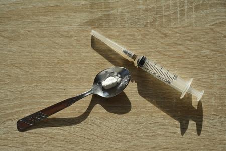 Double exposure effect of a hypodermic needle syringe and a silver spoon of opiate narcoticの写真素材
