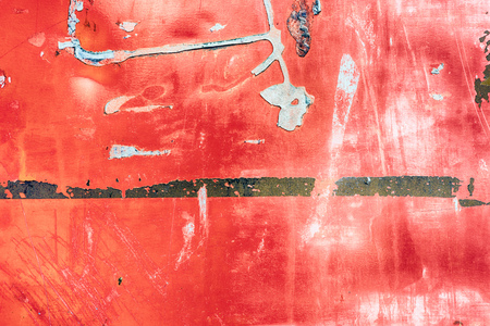 Dirty worn grunge style background of red paint and signs of vandalism and damage from aging
