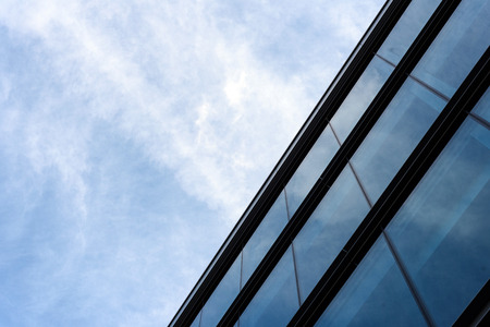 Modern business building with an abstract architecture slant of everyday modernity with a blue and white skyの写真素材