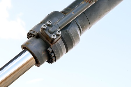 Black hydraulic arm of a digger excavator earthmoving machine with a sky backgroundの写真素材