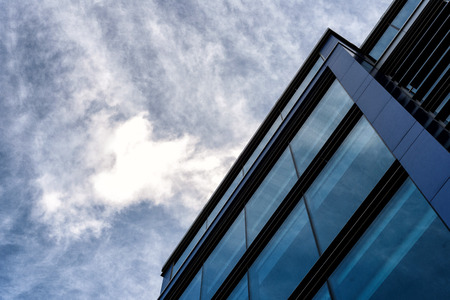 Modern business building with an abstract architecture slant of everyday modernity with a blue and white skyの写真素材