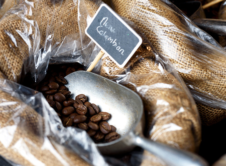 Close-up image of coffee beans in a hessian sack with a silver spoon on display at a farmerâs marketの写真素材