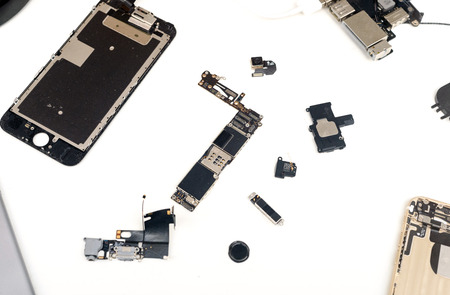 Broken components of an apple macbook ipad computer on a white background with a copyspace area for...