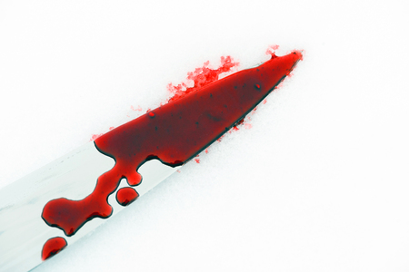 Sharp metal kitchen knife edge used as a violent murder weapon with blood drops on a white snow background. Blade covered in violence with copy space area for domestic crime criminal designsの写真素材