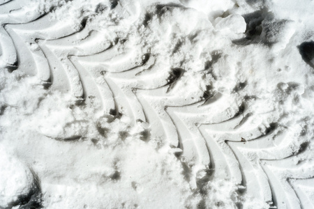 Car tire tracks in fresh winter snow with imprints in the cold winter snowfallの写真素材