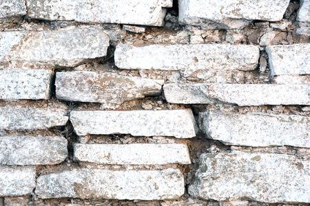 Old stacked tile wall with white wash paint in an old worn stateの写真素材