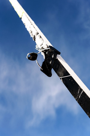 Single new cross-country ski set against a blue winter sky with defocused clouds in the background with a copy space area for wintery themed sports and Nordic skiing designsの写真素材