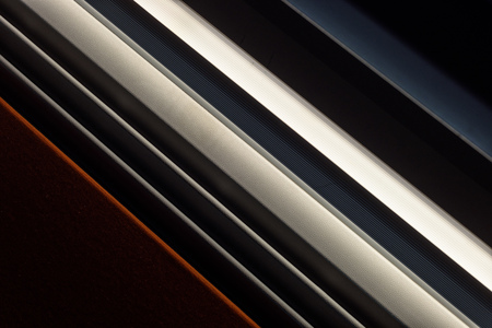 Diagonal lights and slits creates a dark abstract of form and repetitionの写真素材