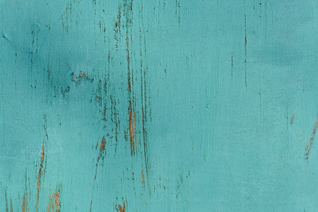 Scratched paint on a wooden plywood background with damage to the green grey paint exteriorの写真素材
