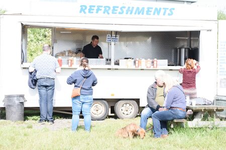 CHELMSFORD, ESSEX/ENGLAND - 1ST JUNE 2019 - People visiting a car boot sale in Boreham Essex buying fast food bugers and where they can also buy cheap and unusual items during the summer of 2019のeditorial素材