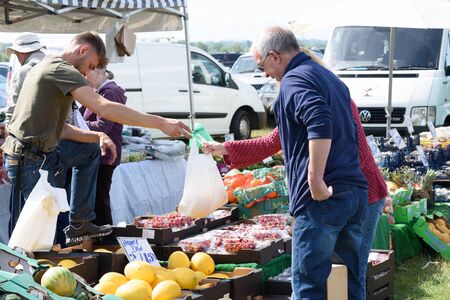 CHELMSFORD, ESSEX/ENGLAND - 1ST JUNE 2019 - People visiting a car boot sale in Boreham Essex buying fruit and vegetables and where they can also buy cheap and unusual items during the summer of 2019のeditorial素材