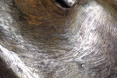 Bronze carving details in closeup macro view with attention to the strikes and curves of bronze and molten lead forming a unique pattern in metalの写真素材
