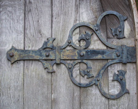 An Iron decorative hinge on a weathered oak door の写真素材