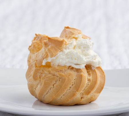 Big eclair appetizer looks eatable with mousse cream on dish 