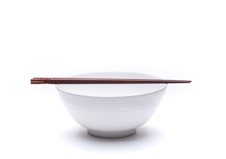 Empty noodle bowl with chopsticks on top isolated on white backgroundの写真素材