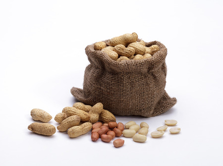 Peanuts in the bag sack isolated on white backgroundの写真素材