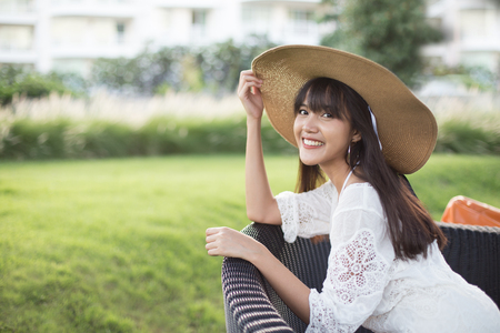 Young beautiful girl happy and relaxing on the armchair, Hua Hin, Thailandの写真素材