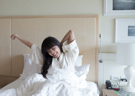 Young sleepy girl on her bed in the morningの写真素材