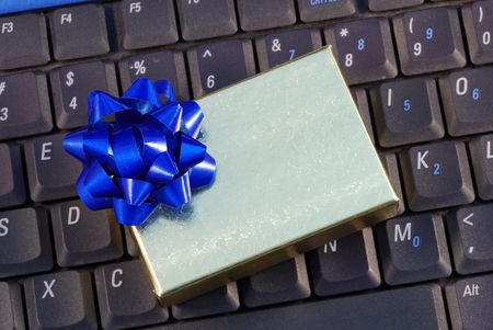 Holiday gift box on a keyboard concepts of holiday online shoppingの写真素材