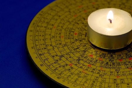 Chinese Feng Shui compass with the candle isolated on blueの写真素材