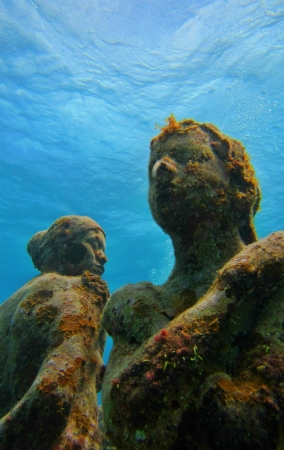 A unique perspective of statues with coral growing on them のeditorial素材