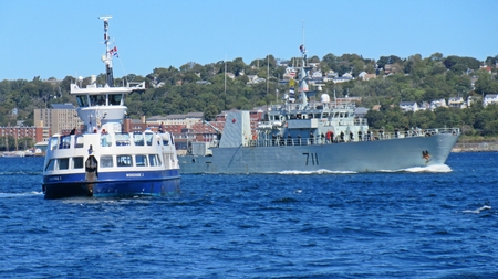 Halifax passenger ferry stops for naval ship in Halifax Nova Scotia harbor as it departs into the Atlantic coast during NATO exercises.のeditorial素材