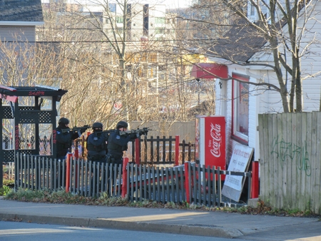 Police SWAT team members approaching suspects houseのeditorial素材