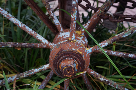 Old Weathered Wagen Wheel With Rust And Yellow Blue Spotsの写真素材