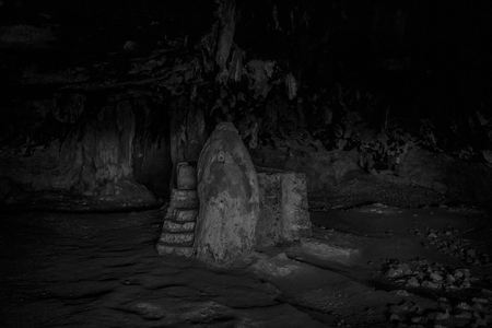 Rock and well in the middle of huge dark caveの写真素材