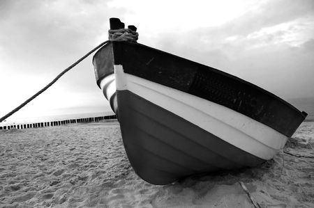 Old fishboat on sandy beach. Beautiful sunset - Baltic Sea in Polandの写真素材