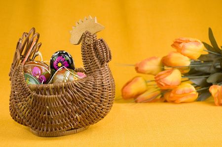 willow hen basket with colorful easter eggs の写真素材