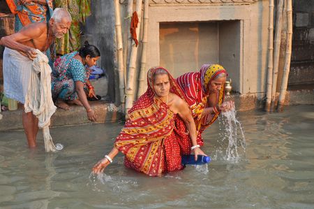 Varanasi, India - 29 October, 2009: An unidentified group of indian people wash themselves in the river Ganga on October 29, 2009.  The holy ritual of washing is held every day.のeditorial素材