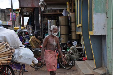 MADURAI, INDIA - 7 NOVEMBER, 2009: Poor indian man nearly without dress walks on the street in Madurai on November 7, 2009. Poverty is the serious problem in the whole India.のeditorial素材