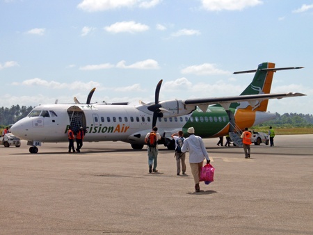 ARUSHA, TANZANIA - 6 JANUARY, 2009: Tourists head to a small airplane that just landed at Arusha...
