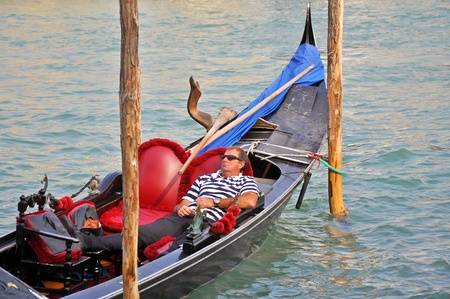 VENICE, ITALY - 30 SEPTEMBER, 2009: Gondolier has a rest in gondola on the Grand Channel on September 29, 2009. The profession of gondolier is controlled by a guild, which issues a limited number of licenses. のeditorial素材
