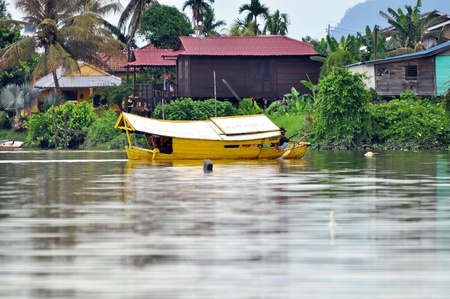 KUCHING, SARAWAK, BORNEO - MAY 4, 2010: Local boatman crosses the river to pick up the customers on May 4, 2010 in Kuching, Borneo. Using of small boats is the only way how to cross the wide river in Kuching.のeditorial素材
