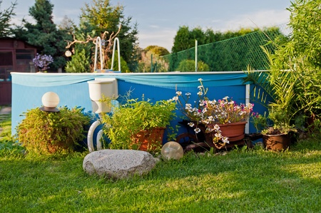 Swimming pool in a garden during the sunset time.