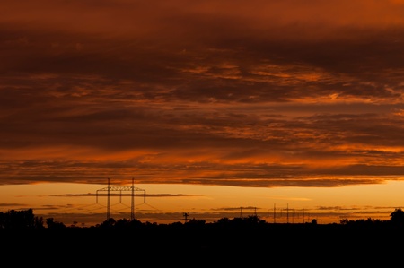 Electric power transmission lines at sunset time.の写真素材